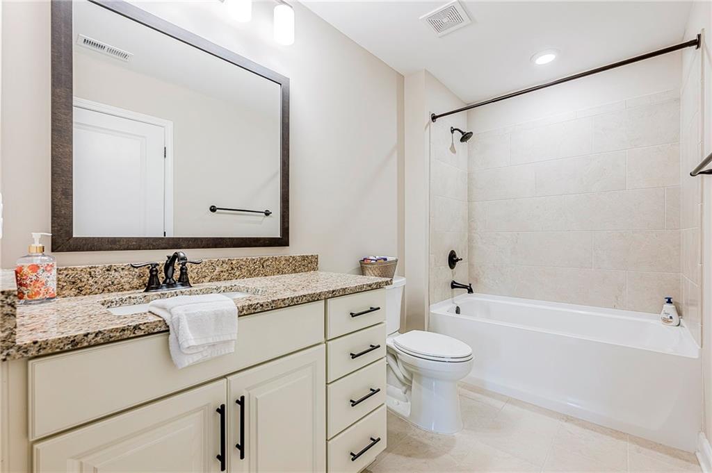 701 Calypso Way Cumming, GA 30040 - Photo 34 of 54 a bathroom with a granite countertop sink a toilet and a large mirror