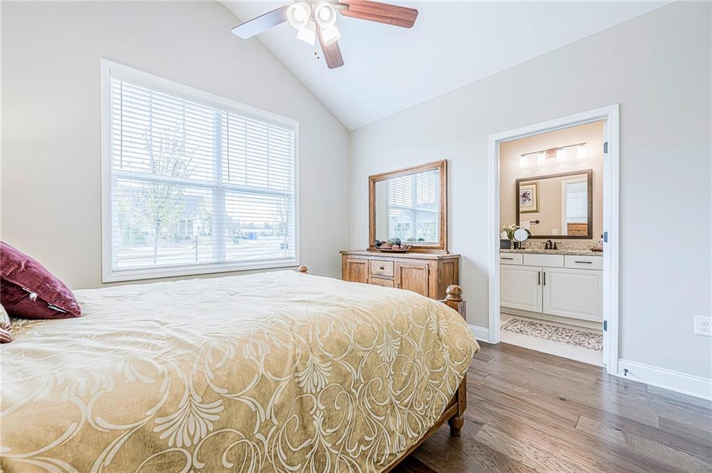 701 Calypso Way Cumming, GA 30040 - Photo 10 of 54 a bedroom with a large bed and a chandelier