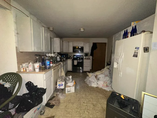 a kitchen with refrigerator and cabinets