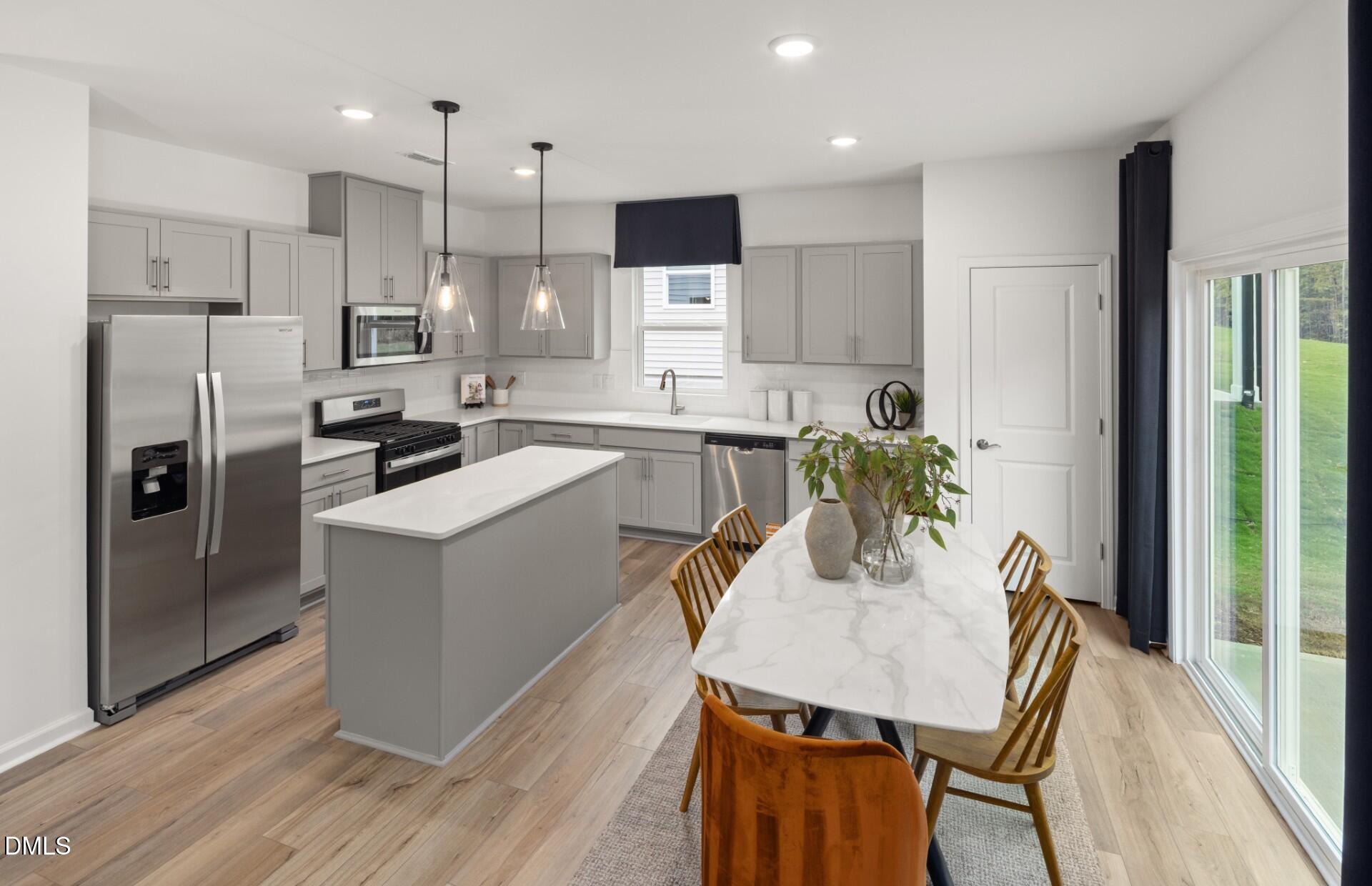 605 Timber Terrace Drive Durham, NC 27704 - Photo 8 of 31 a kitchen with refrigerator cabinets dining table and chairs
