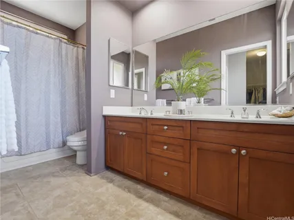 a bathroom with a double vanity sink toilet and a mirror