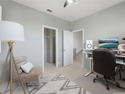 a view of a workspace with furniture and a window