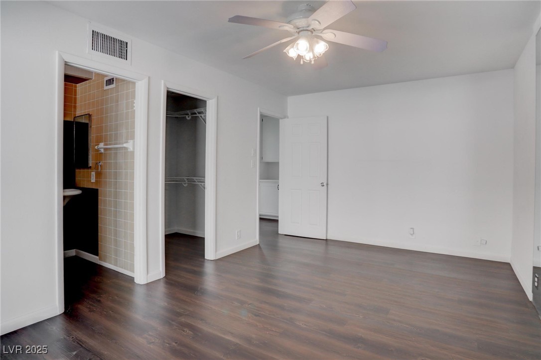 4775 Monaco Road Las Vegas, NV 89121 - Photo 14 of 31 Unfurnished bedroom with ceiling fan, a closet, dark hardwood / wood-style floors, and a walk in closet