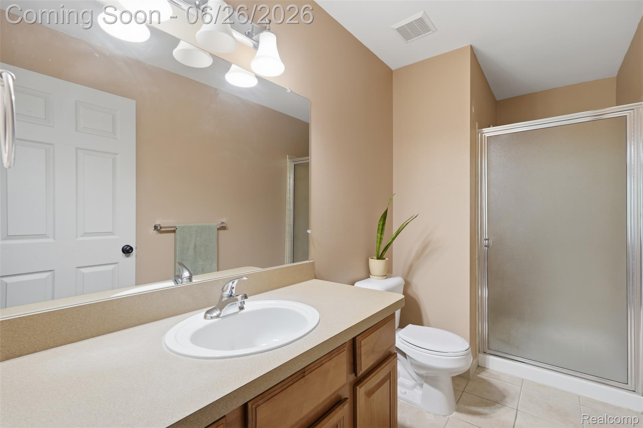 1668 Deepwood Circle Rochester, MI 48307 - Photo 21 of 27 Bathroom featuring a wood-finish vanity with a light-toned countertop, an oval sink with a chrome faucet, and a large wall-mounted mirror