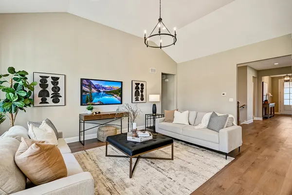 a view of a dining room and livingroom with furniture wooden floor a chandelier