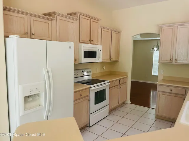 a kitchen with a refrigerator sink and cabinets