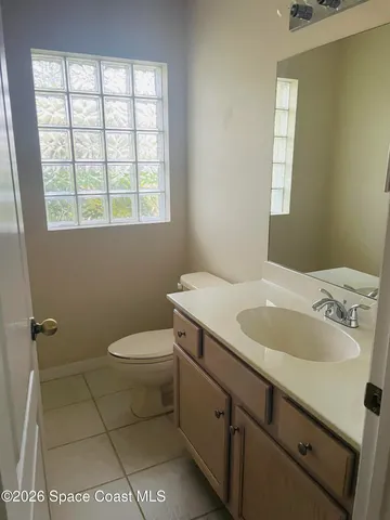 a bathroom with a granite countertop sink toilet and mirror