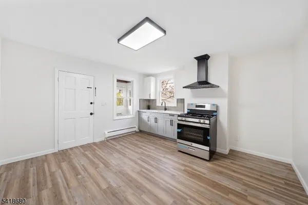 a kitchen with granite countertop a sink cabinets and wooden floor