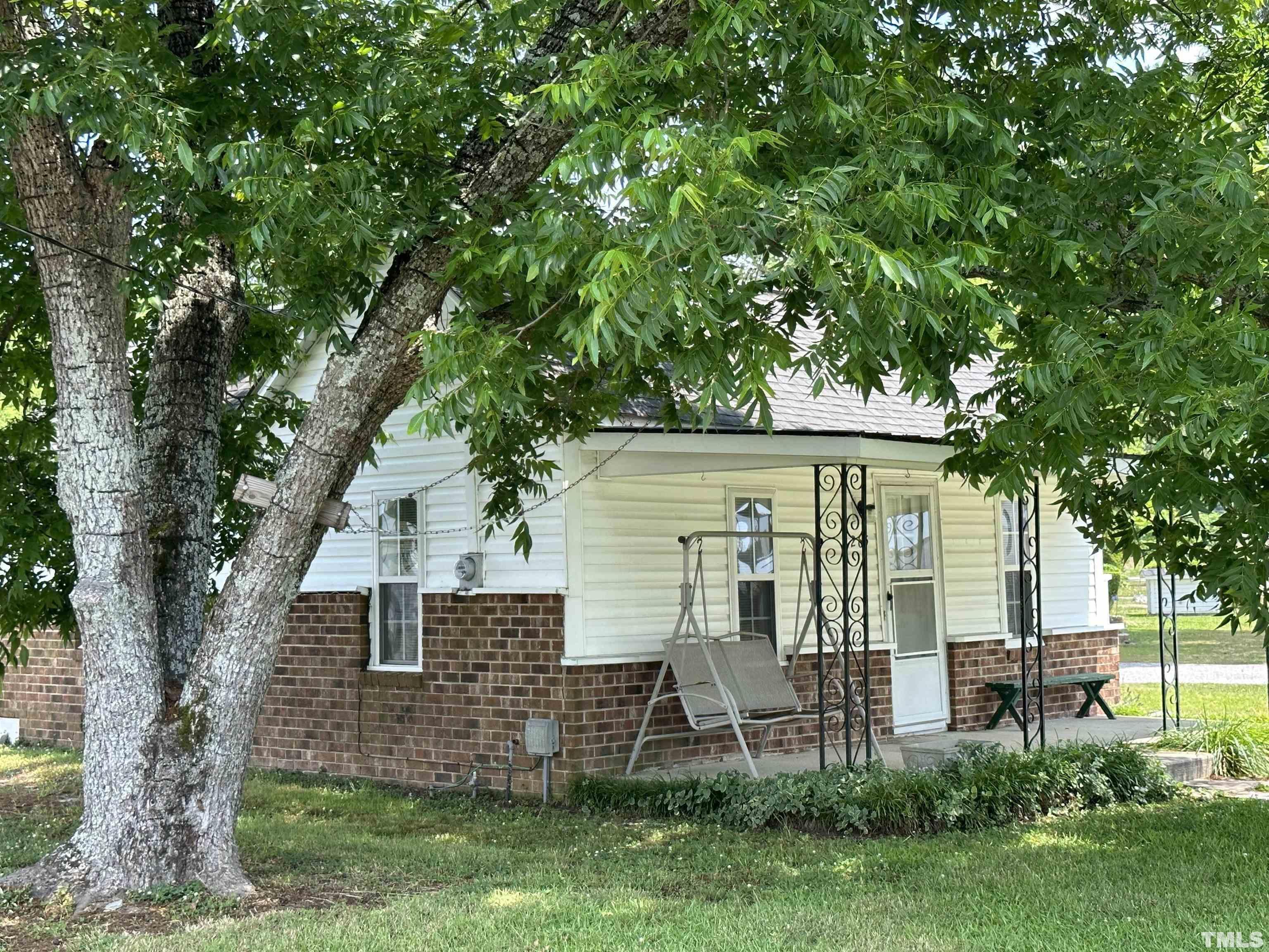 a view of backyard of house with green space