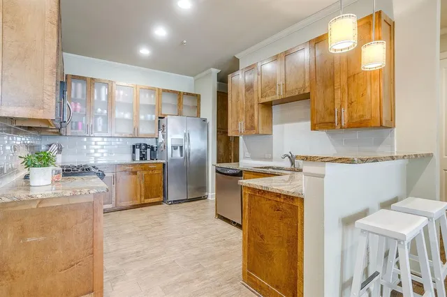a kitchen with a refrigerator a sink dishwasher with wooden cabinets and a large window