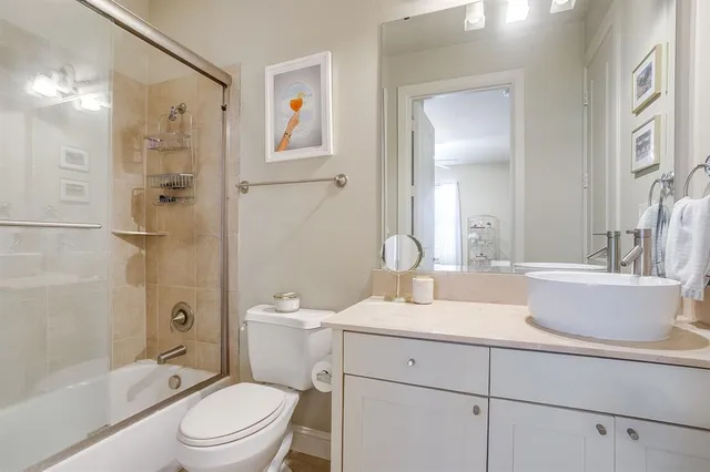 a bathroom with a granite countertop sink toilet a shower and a mirror