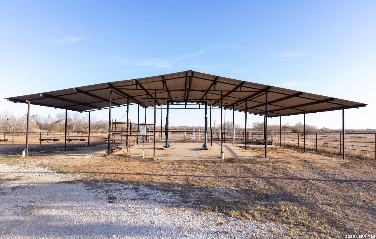 375 Bluntzer Road Jourdanton, TX 78026 - Photo 15 of 44 a blue swimming pool with lawn chairs under an umbrella