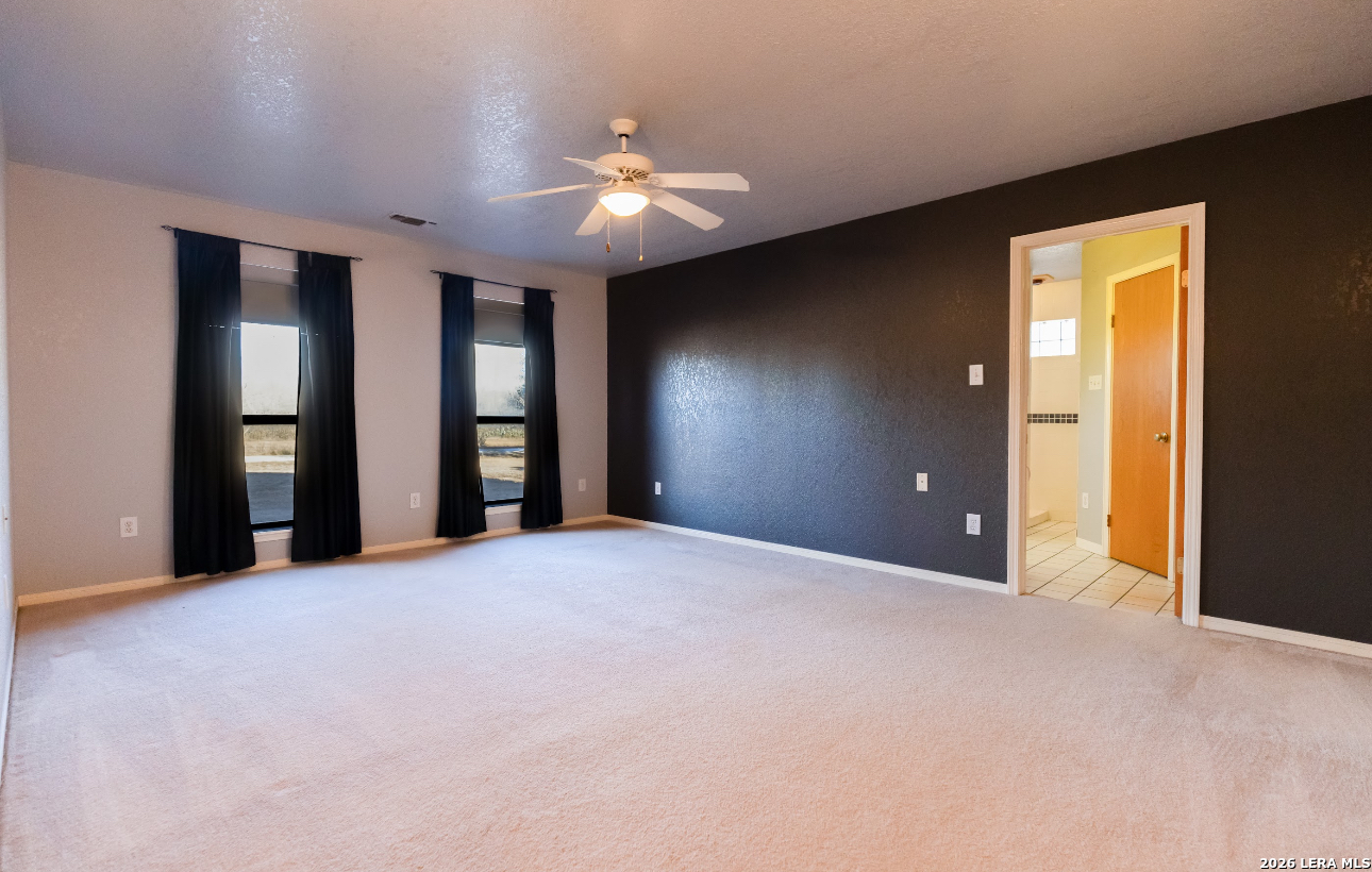375 Bluntzer Road Jourdanton, TX 78026 - Photo 28 of 44 a view of an empty room with window and chandelier