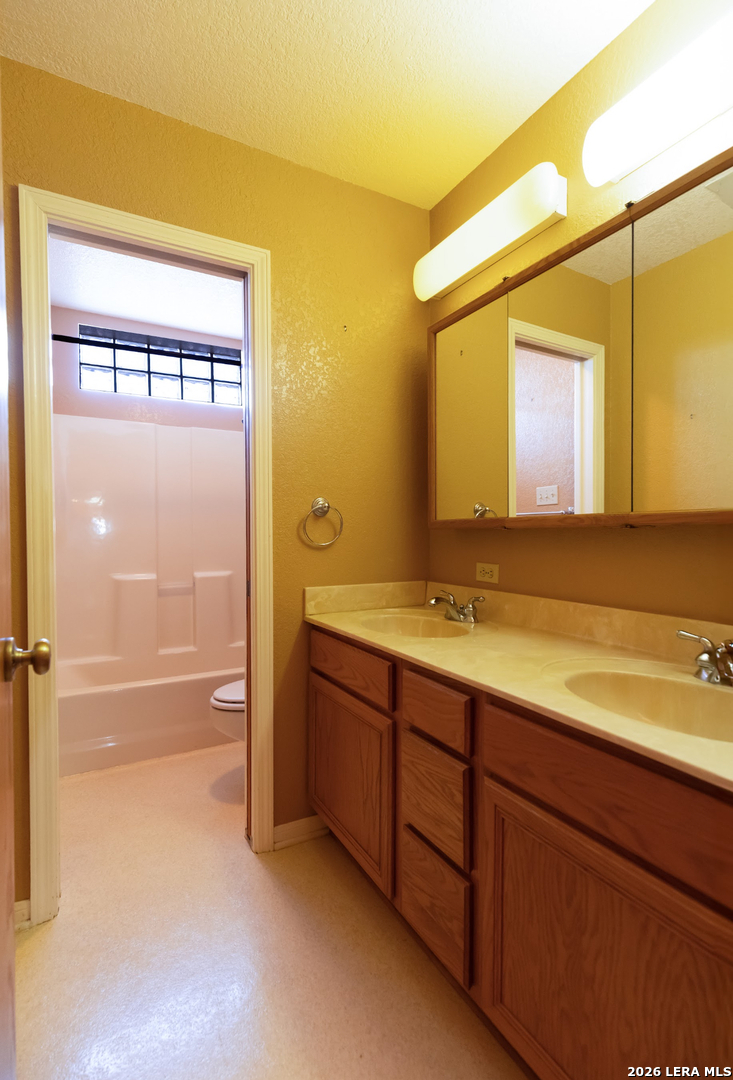 375 Bluntzer Road Jourdanton, TX 78026 - Photo 37 of 44 a bathroom with a granite countertop sink and a mirror