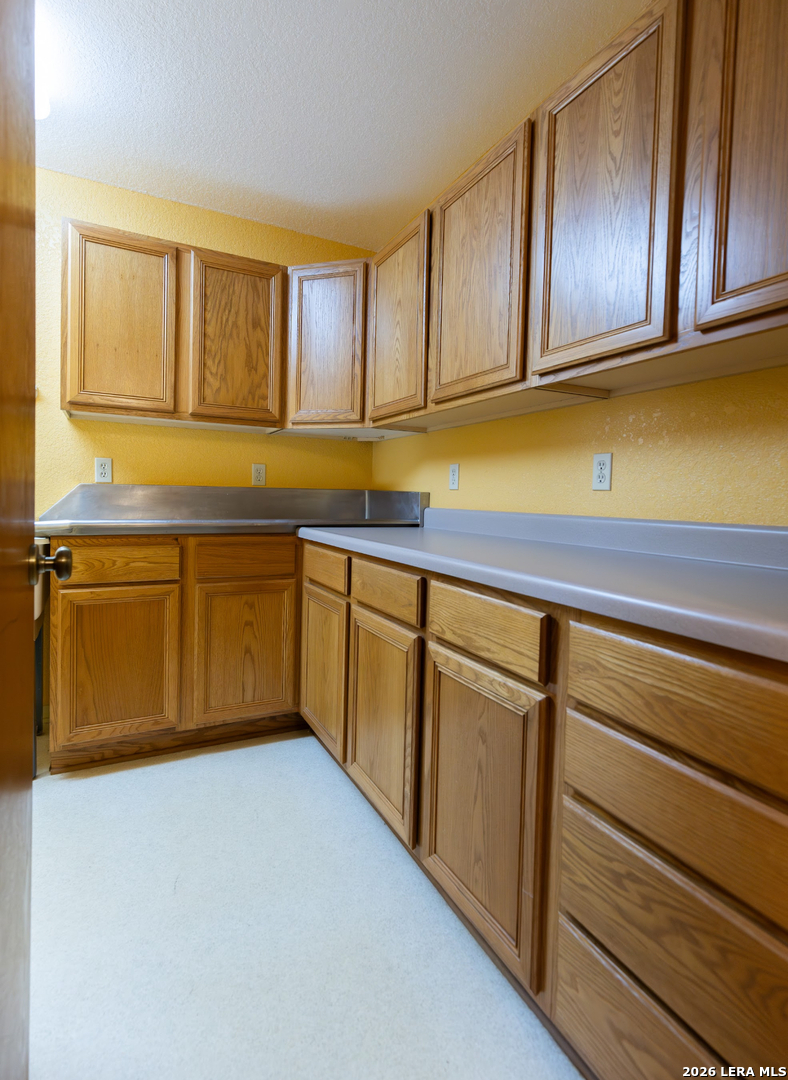 375 Bluntzer Road Jourdanton, TX 78026 - Photo 39 of 44 a kitchen with wooden cabinets and a sink