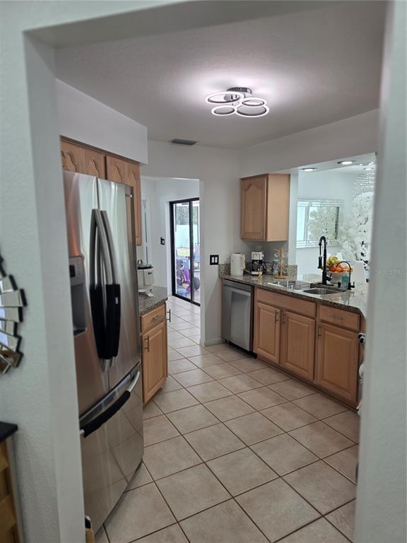 13128 Hazelcrest Street Spring Hill, FL 34609 - Photo 11 of 46 a kitchen with stainless steel appliances granite countertop a refrigerator and a sink