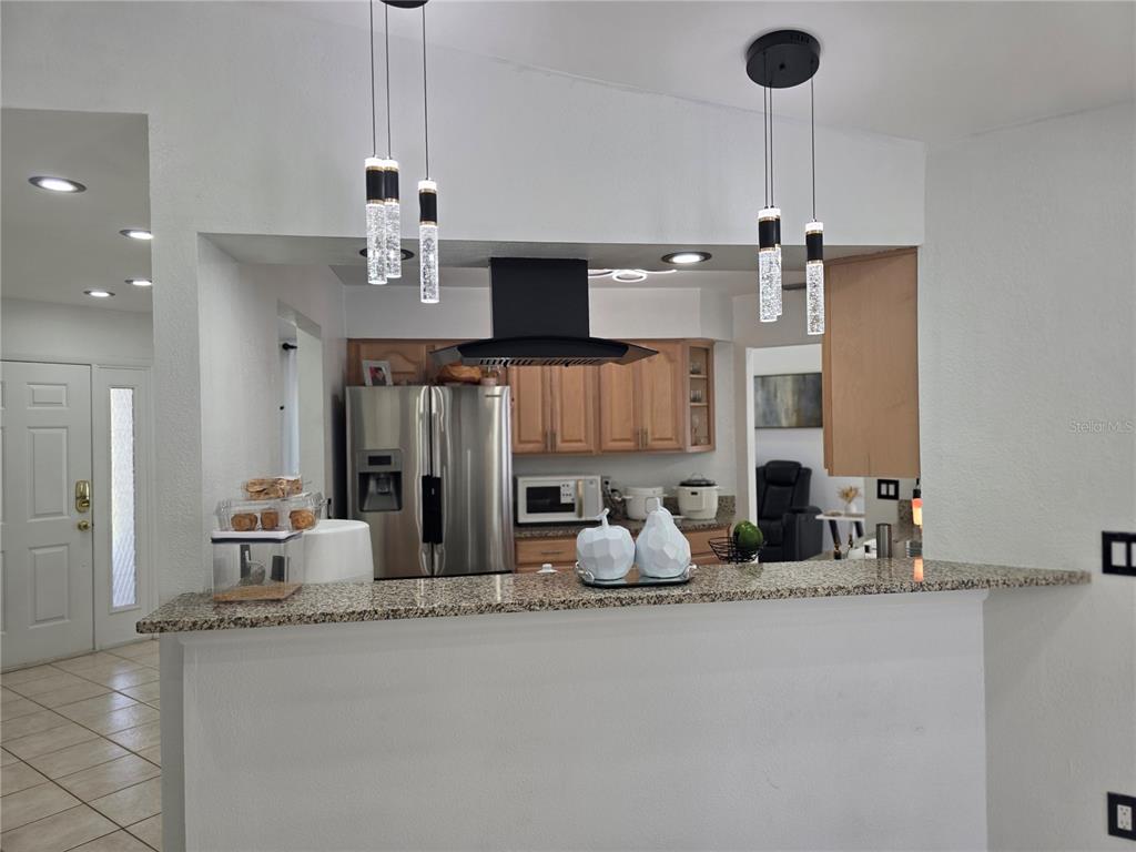 13128 Hazelcrest Street Spring Hill, FL 34609 - Photo 14 of 46 a kitchen with stainless steel appliances granite countertop a sink and a refrigerator