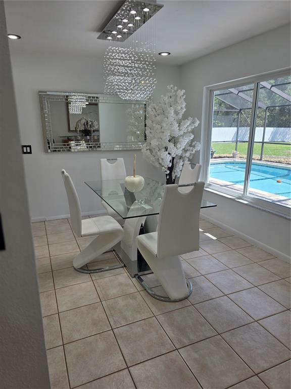 13128 Hazelcrest Street Spring Hill, FL 34609 - Photo 18 of 46 a view of a dining room with furniture and a floor to ceiling window