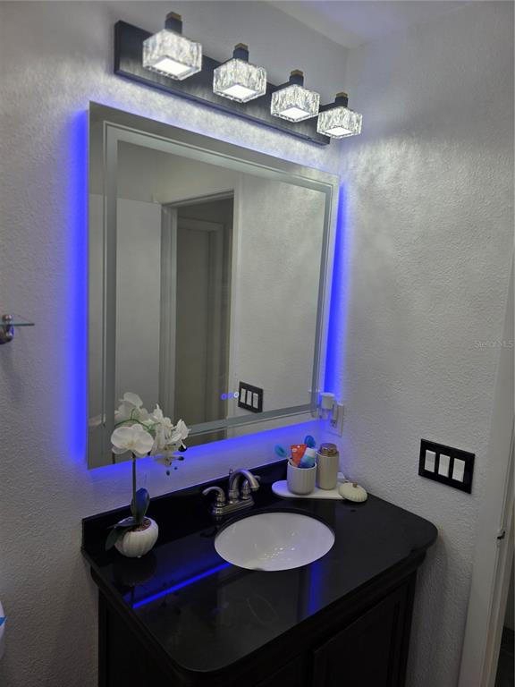 13128 Hazelcrest Street Spring Hill, FL 34609 - Photo 20 of 46 a bathroom with a sink vanity and a mirror