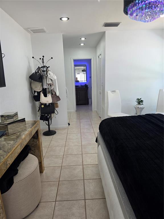 13128 Hazelcrest Street Spring Hill, FL 34609 - Photo 28 of 46 a bedroom with a bed and a chandelier