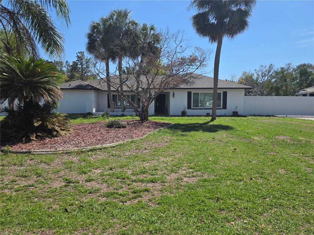 13128 Hazelcrest Street Spring Hill, FL 34609 - Photo 3 of 46 a house view with a garden space