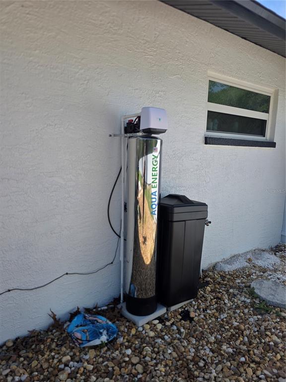 13128 Hazelcrest Street Spring Hill, FL 34609 - Photo 35 of 46 a room with a wooden floor and a potted plant on a table