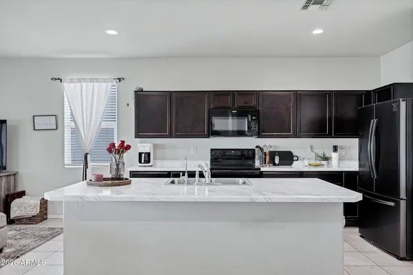 a kitchen with stainless steel appliances a sink a stove and a refrigerator with wooden floor
