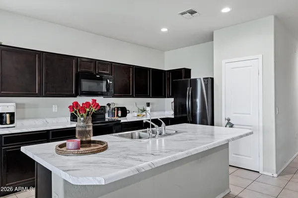 a kitchen with granite countertop a sink and a refrigerator