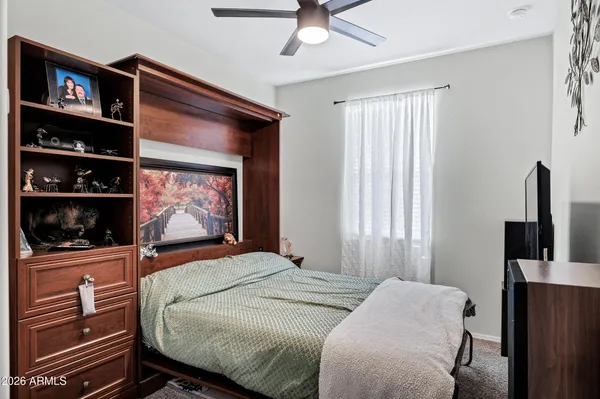 a bedroom with a bed a dresser and book shelf