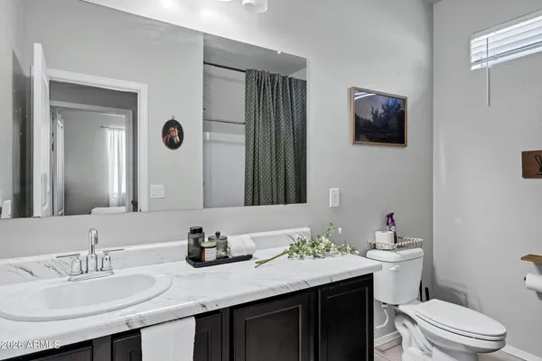 a bathroom with a granite countertop sink mirror and toilet