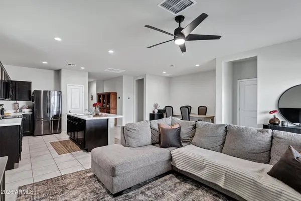 a living room with furniture kitchen view and a wooden floor