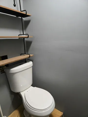 a white toilet sitting next to a shower