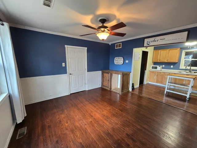 a view of a livingroom with wooden floor and a ceiling fan