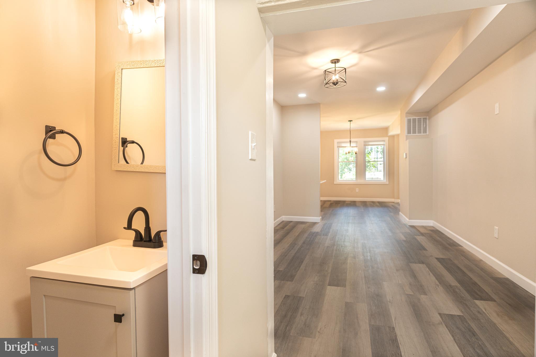 2808 Waldorf Avenue Baltimore, MD 21215 - Photo 11 of 26 a bathroom with a sink and mirror with window