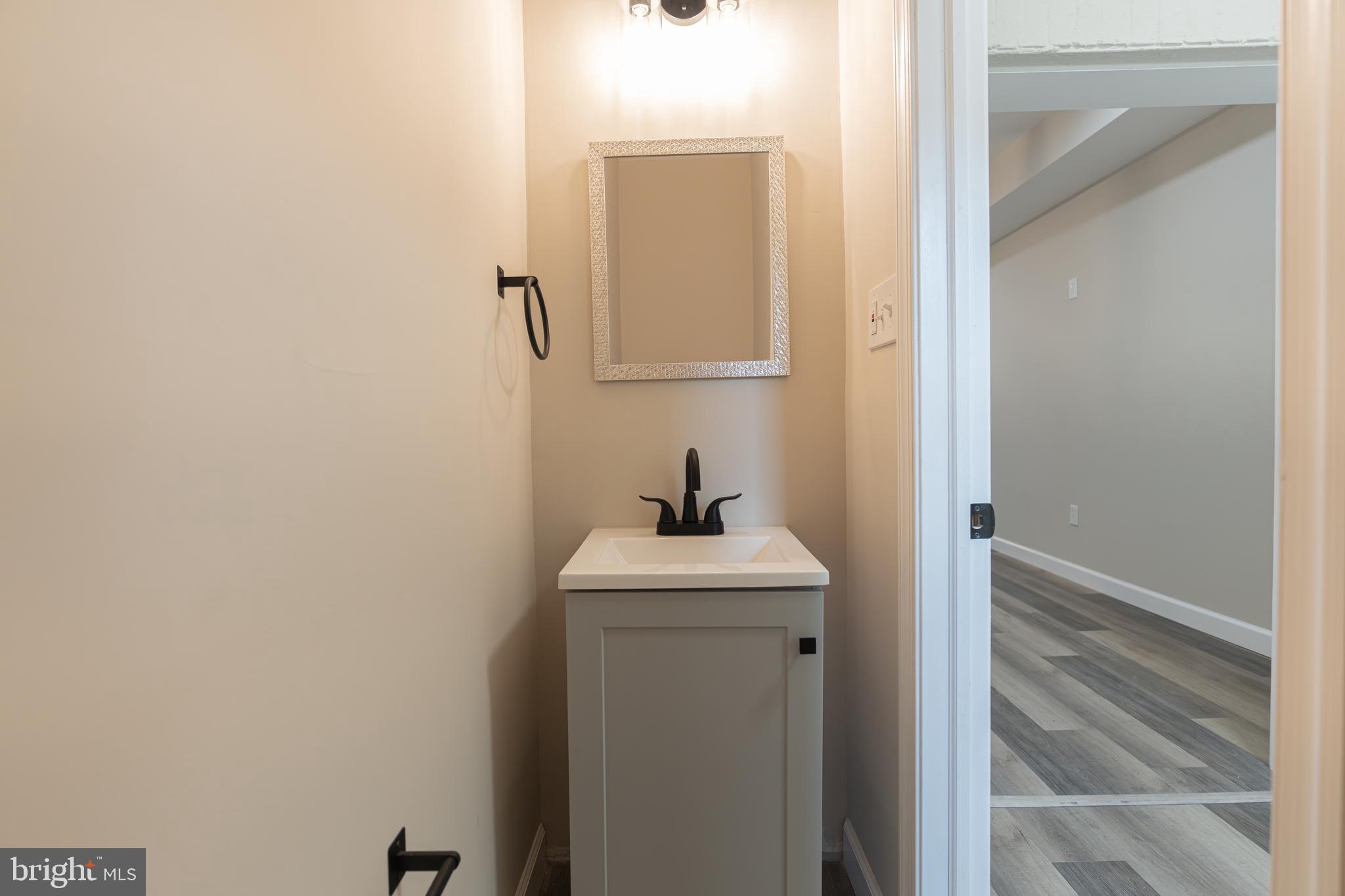 2808 Waldorf Avenue Baltimore, MD 21215 - Photo 12 of 26 a bathroom with a sink and mirror