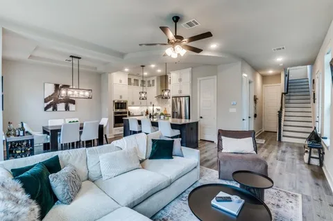 a living room with furniture and a chandelier