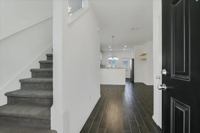 a view of a hallway with wooden floor and staircase