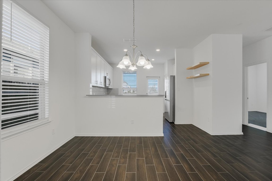 661 Pickrell Loop Georgetown, TX 78628 - Photo 7 of 27 wooden floor in an empty room with a window