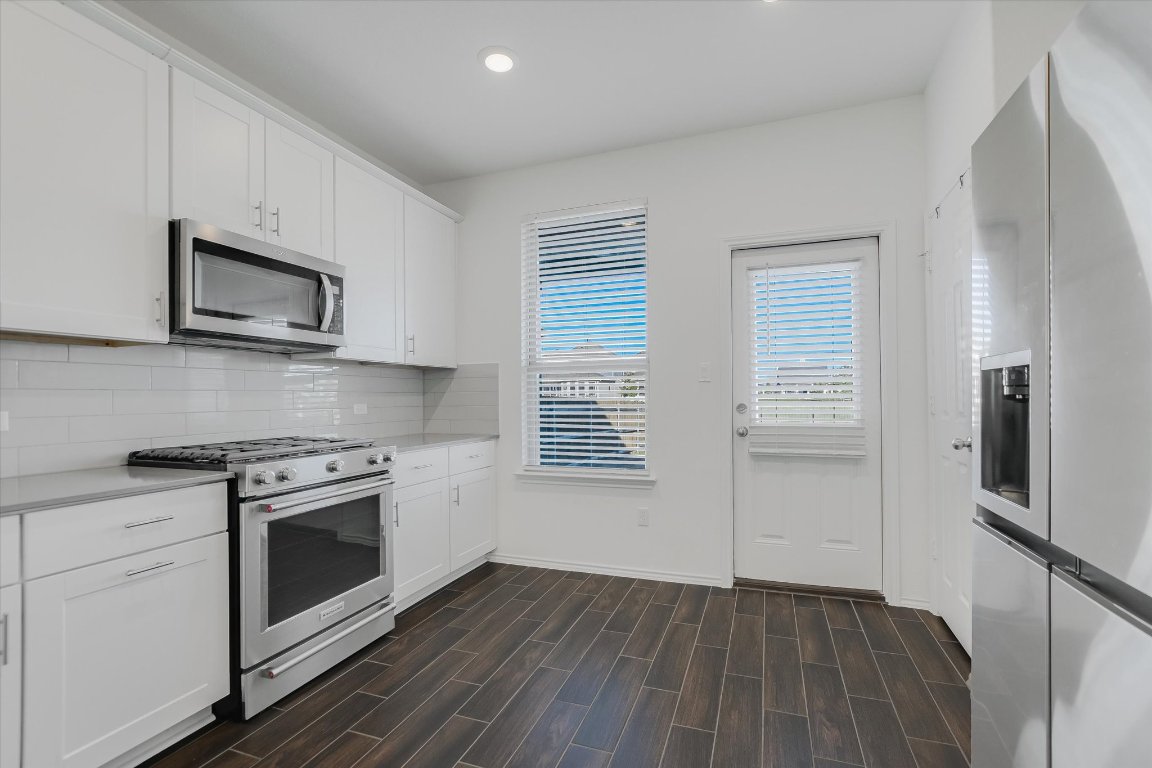 661 Pickrell Loop Georgetown, TX 78628 - Photo 9 of 27 a kitchen with a stove microwave and sink