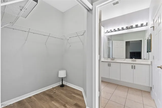 a view of a hallway with closet and chandelier fan