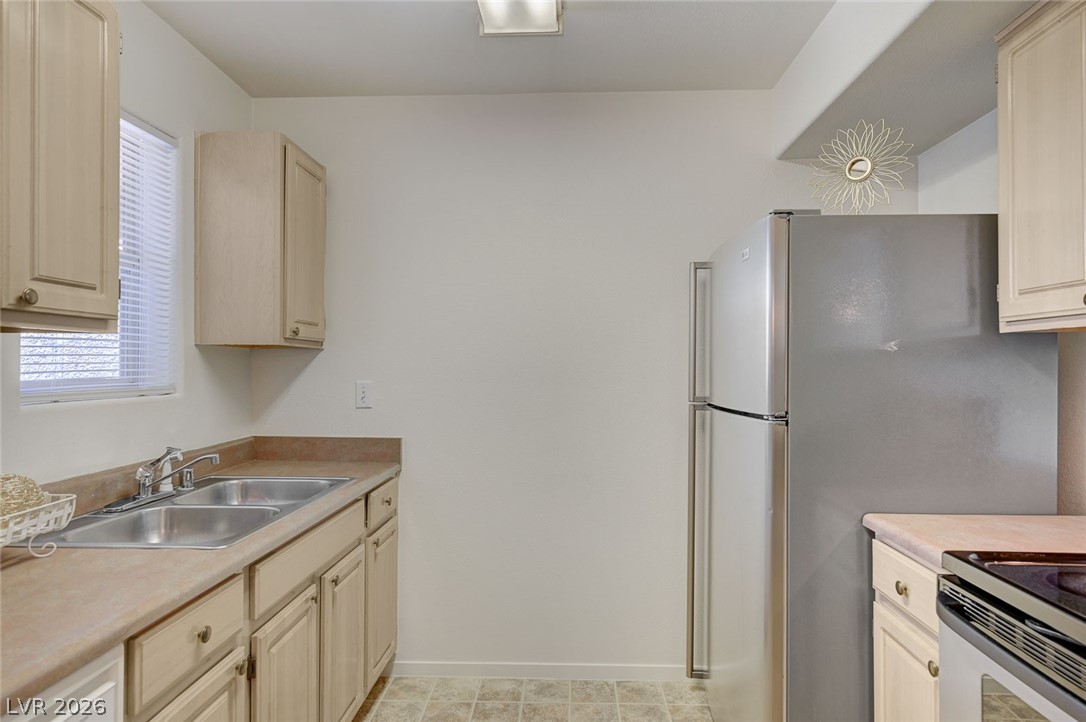 555 East Silverado Ranch Boulevard, Unit 2124 Las Vegas, NV 89183 - Photo 17 of 47 A well-equipped kitchen features a dual basin sink and stainless steel refrigerator.