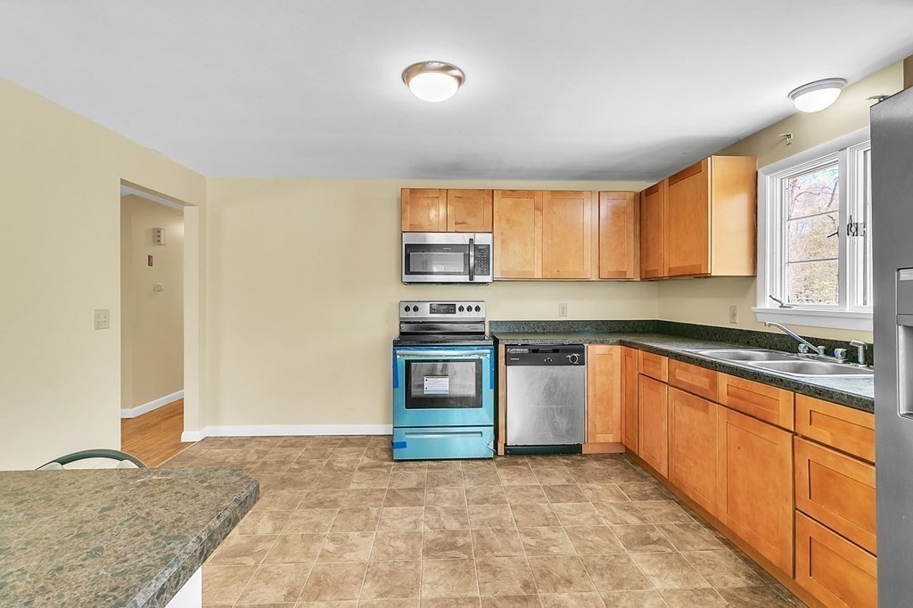 34 1/2 Paradise Lake Road Monson, MA 01057 - Photo 16 of 30 a kitchen with stainless steel appliances granite countertop a stove a sink and a refrigerator