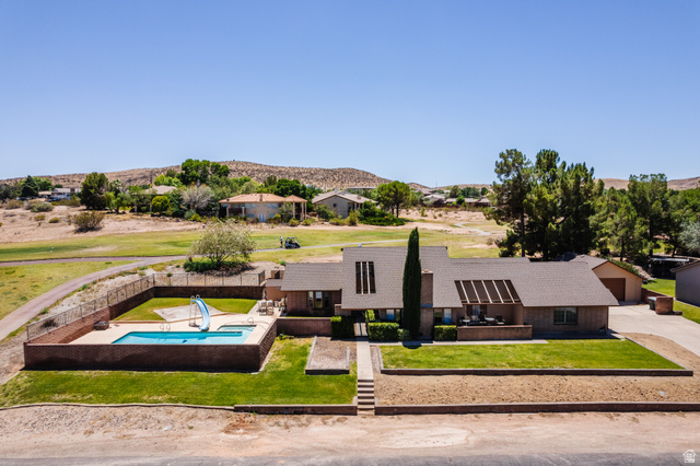 1470 Redwood Tree Street St. George, UT 84790 - Photo 2 of 53 Exterior featuring a rectangular swimming pool, fenced pool deck, and a green lawn