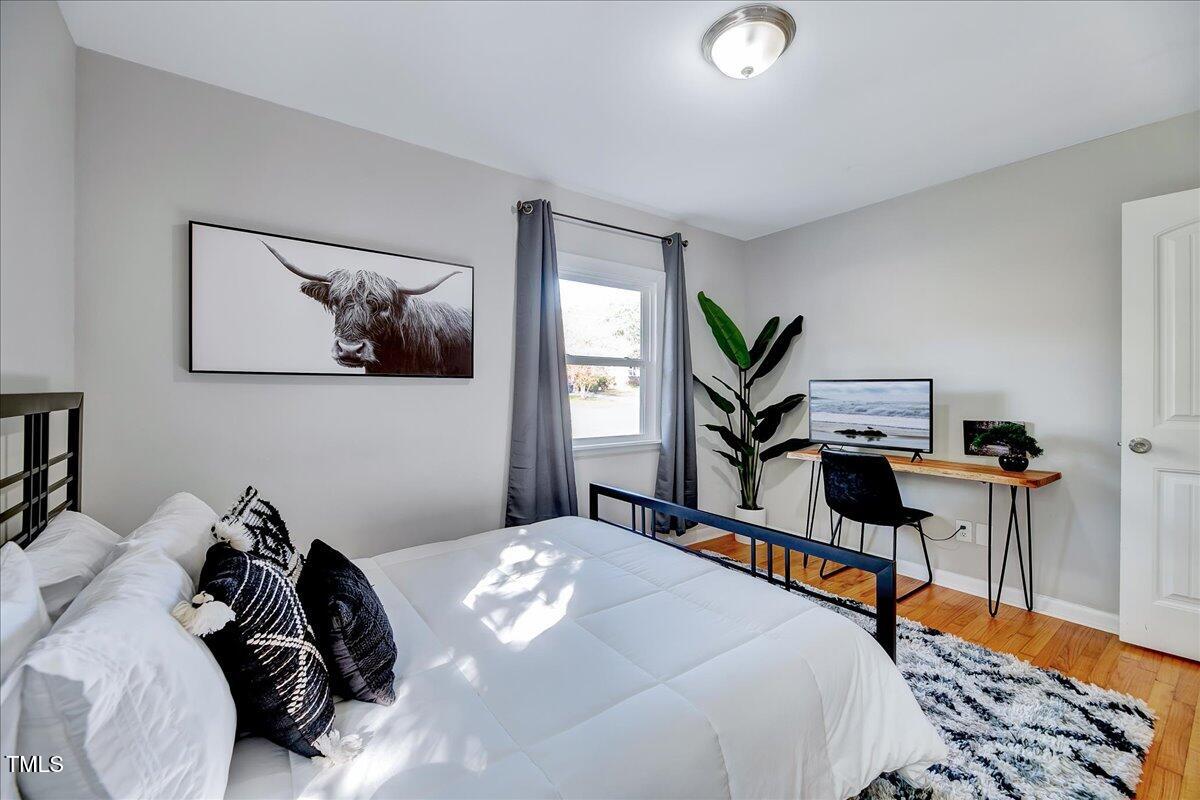 2809 Newark Drive Raleigh, NC 27610 - Photo 18 of 36 a bedroom with a bed and a chandelier