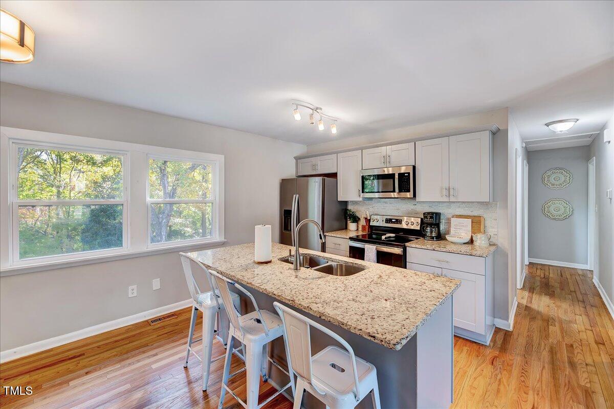 2809 Newark Drive Raleigh, NC 27610 - Photo 9 of 36 a kitchen with granite countertop stainless steel appliances and wooden cabinets