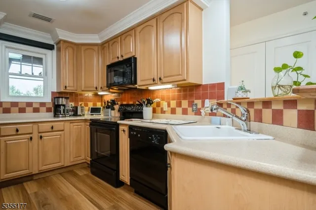 a kitchen with granite countertop stainless steel appliances stove microwave and cabinets