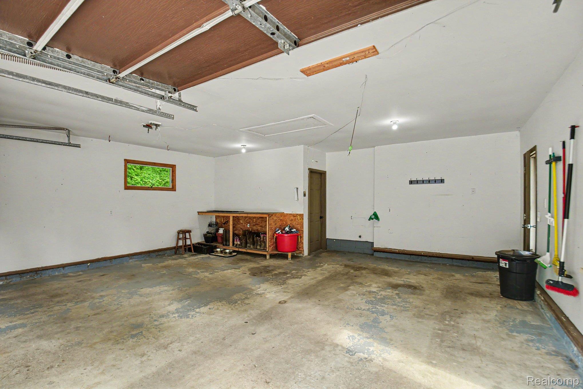 1646 Boy Scout Road Caro, MI 48723 - Photo 16 of 28 Spacious two-car garage featuring a window, built-in workbench, two access doors, and an overhead garage door