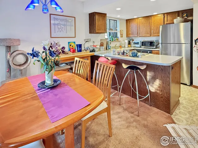 a kitchen with stainless steel appliances granite countertop a sink dishwasher and a dining table with wooden cabinet