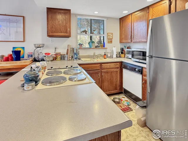 a kitchen with stainless steel appliances granite countertop a refrigerator sink and white cabinets