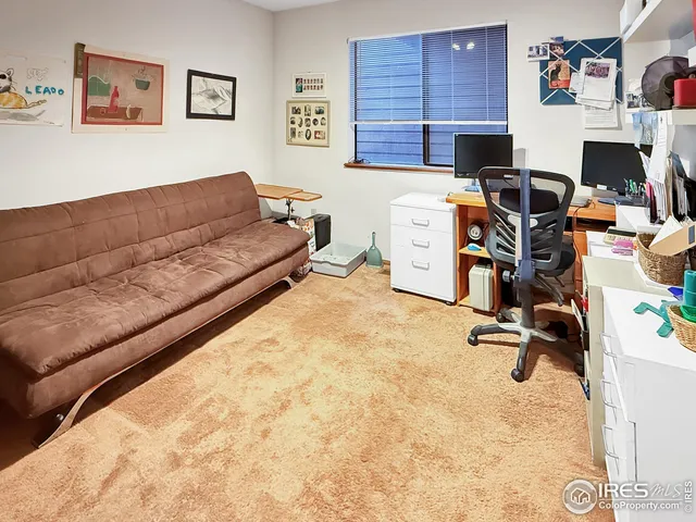 a view of a workspace with furniture and a window